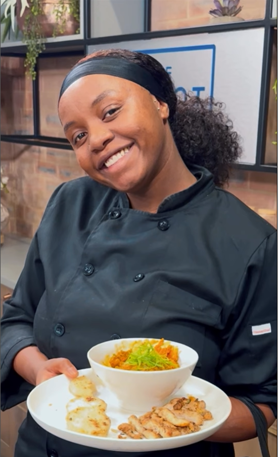 Chef Pinky holding a plate of Chakalaka, prepared with rescued ingredients to promote sustainable cooking and food waste awareness.
